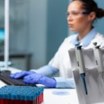 Biologist researcher woman with white coat discovering vaccine against virus