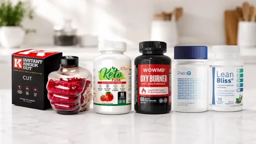 Assorted supplement bottles and a jar of red capsules on a white marble countertop.